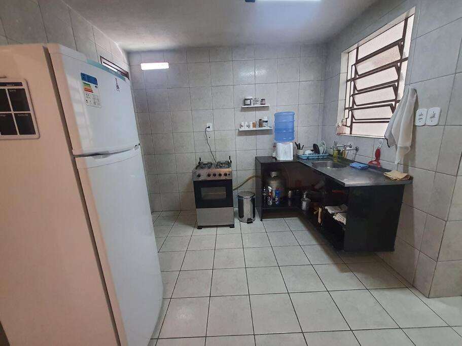 una pequeña cocina con nevera y fregadero en Sua casa em Maceió, en Maceió