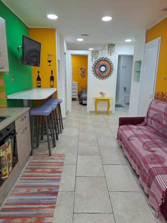 uma sala de estar com paredes amarelas e verdes e um sofá em Napoli Charme em Nápoles
