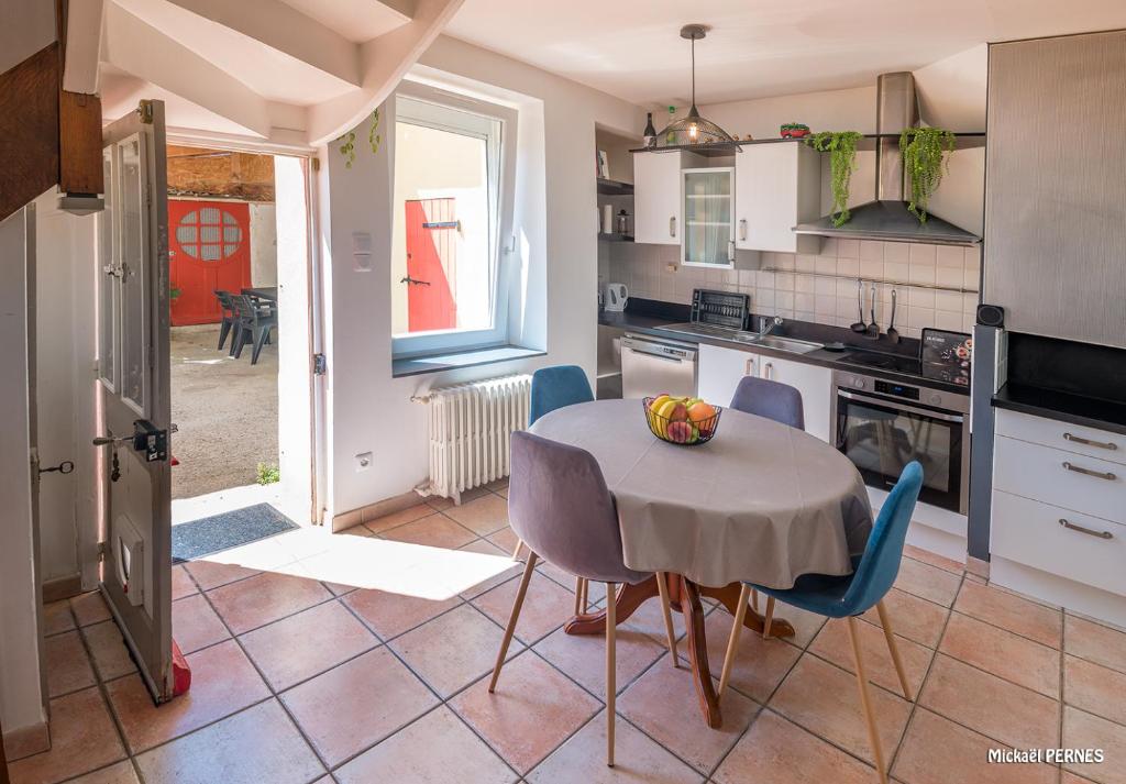 une cuisine avec une table et des chaises dans l'établissement RÉF 398 - HENNEBONT maison de ville de caractère avec jardinet et patio, à Hennebont