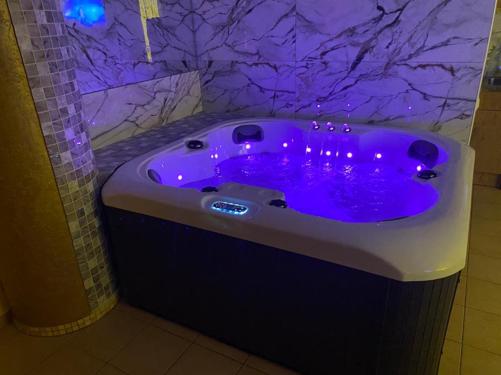 a purple tub with purple lights in a bathroom at Jacuzzi in Klaipėda