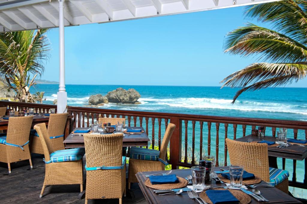 a restaurant with tables and chairs and the ocean at The Atlantis Historic Inn in Saint Joseph