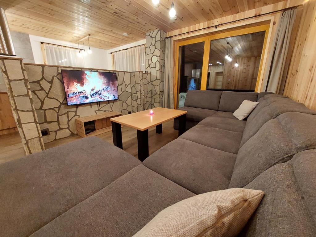 ein Wohnzimmer mit einem Sofa und einem Tisch in der Unterkunft Chaty Hana in Demänovská Dolina