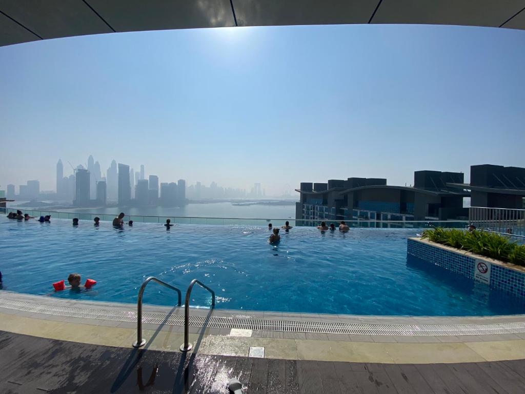 people swimming in a swimming pool on the roof of a building at Serenity Suites studio in Seven Palm corner view in Dubai