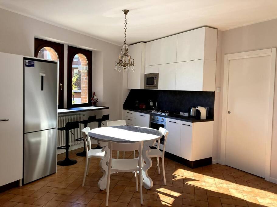 uma cozinha com uma mesa branca e uma cozinha com um frigorífico em Residenza Le Fornaci em Sorisole