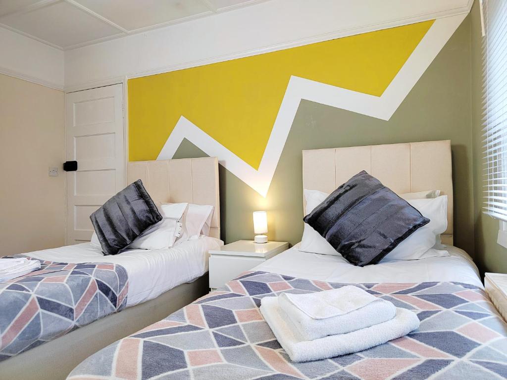 Duas camas sentadas uma ao lado da outra num quarto em Epicsa - 3 Bedroom Family & Corporate Stay, Garden and FREE parking em Cambridge