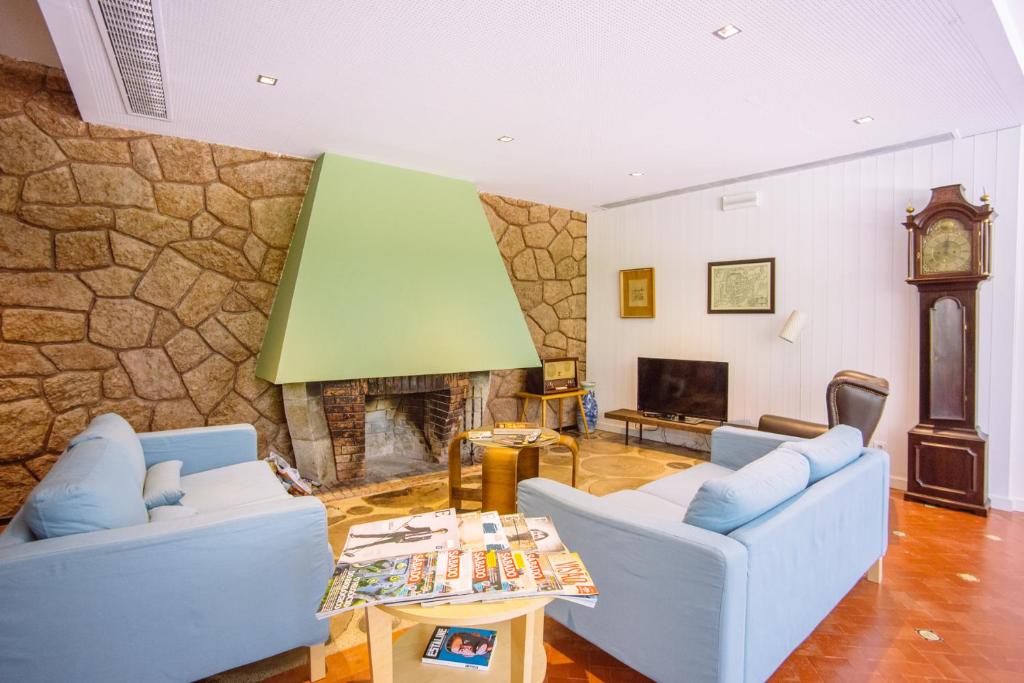a living room with two couches and a fireplace at Hotel Rural Misarela in Sidros