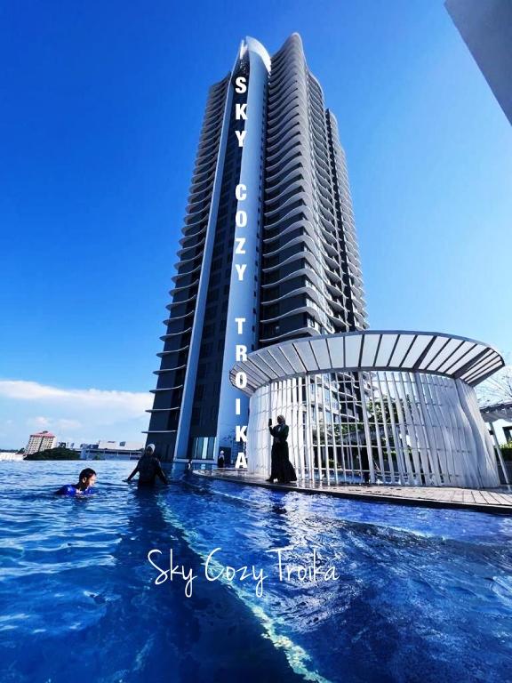 a swimming pool in front of a building at SKY COZY TROIKA RESIDENCE, 1 BEDROOM 4-6 PAX, 2 BEDROOMS 6-8 PAX, POOL VEW, SKY & CITY VIEW, Free Parking, Pool, Unlimited Wifi in Kota Bharu