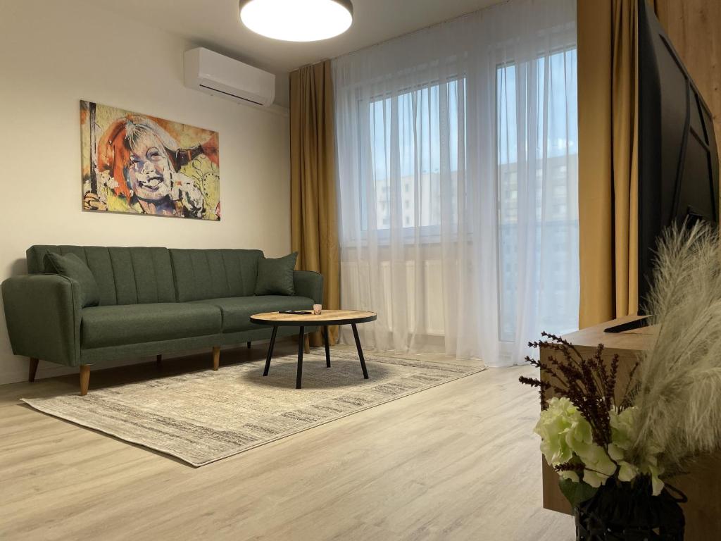 a living room with a green couch and a table at SkyNest A204 in Bratislava