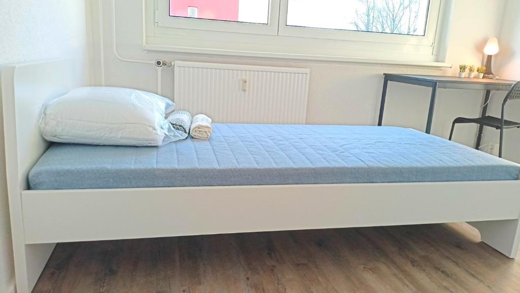 Bett mit blauer Matratze und zwei Schuhen drauf in der Unterkunft Apartkeep Chemnitz 234 in Chemnitz