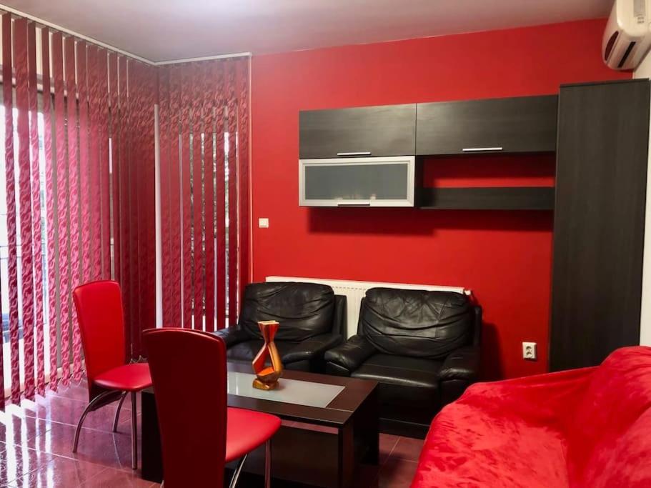 ein rotes Wohnzimmer mit einem Sofa und einem Tisch in der Unterkunft Joy City Stay Martirilor Giroc 4 in Timişoara
