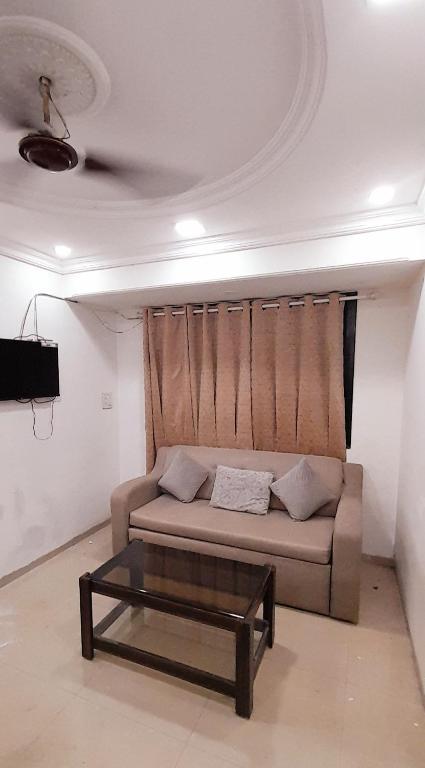 sala de estar con sofá y mesa de centro en Stay in elegant 1bhk, en Navi Mumbai