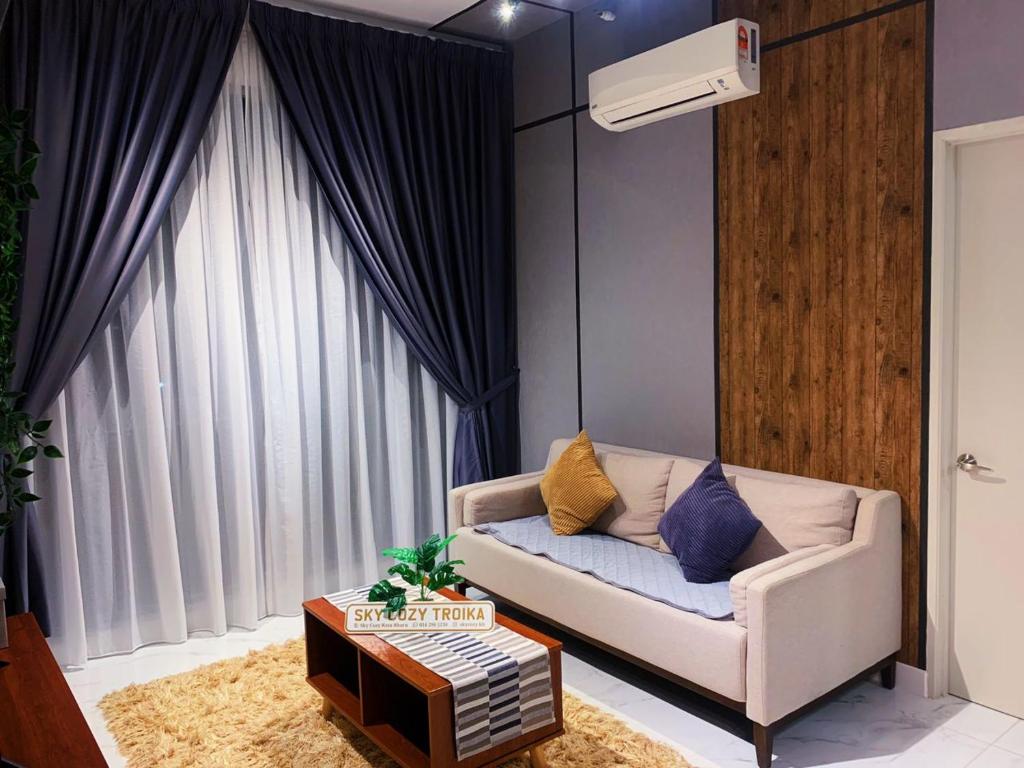 uma sala de estar com um sofá e uma grande janela em SKY COZY TROIKA RESIDENCE, 1 BEDROOM 4-6 PAX, 2 BEDROOMS 6-8 PAX, POOL VIEW, SKY & CITY VIEW, Free Parking, Pool, WiFi, Netflix, Disney Hotstar em Kota Bharu