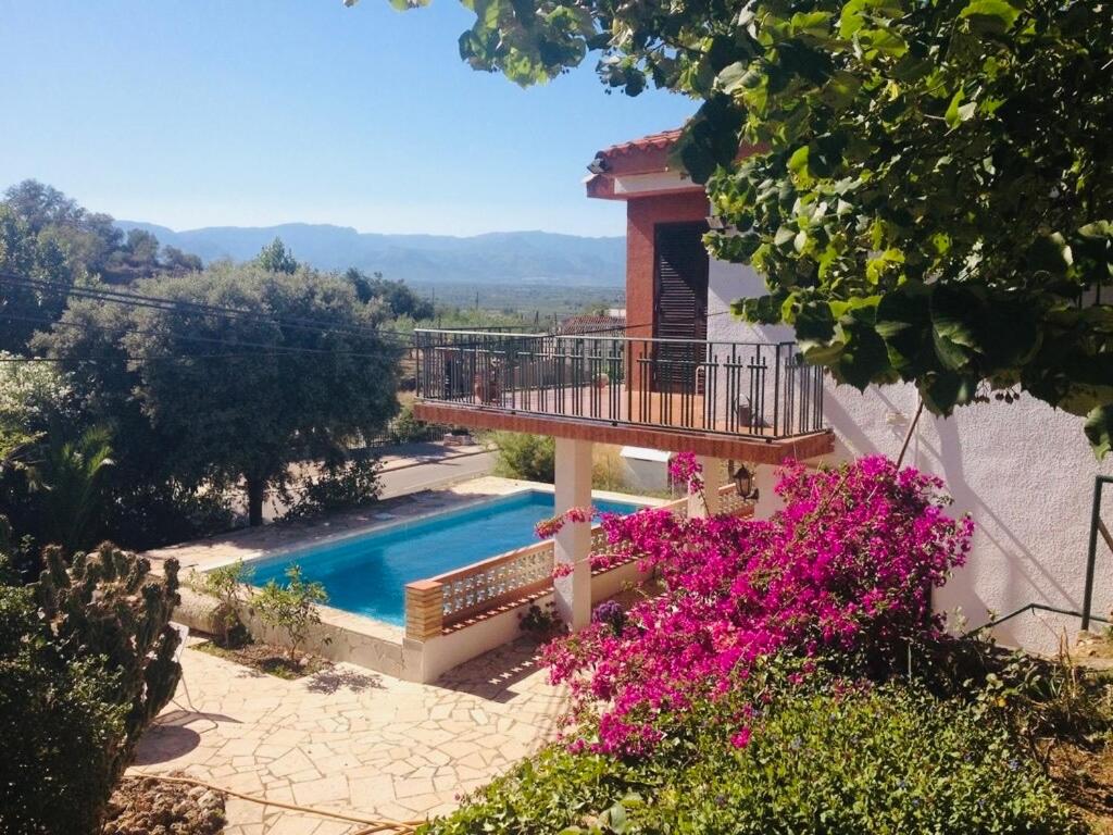 a house with a balcony and a swimming pool at Country house Godall in La Galera