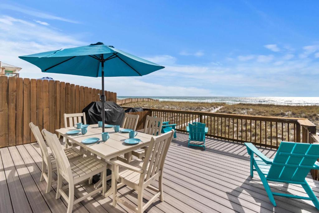 ein Tisch und Stühle mit einem Sonnenschirm auf einem Deck in der Unterkunft Breezeway in Navarre