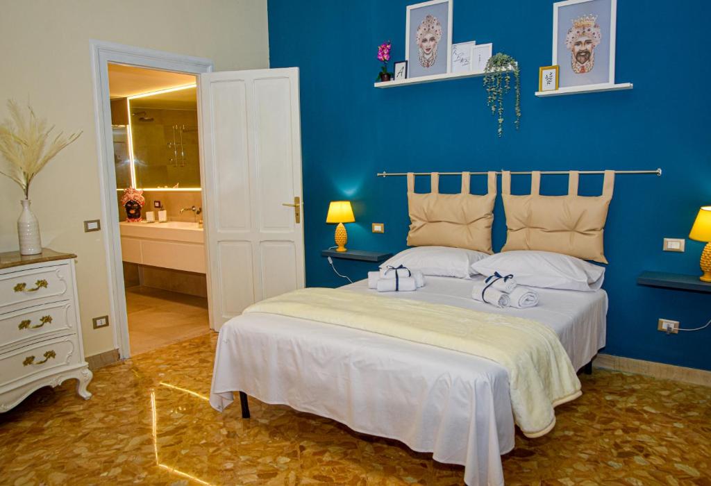 a bedroom with a bed with a blue wall at Alba e i Mori in Palermo