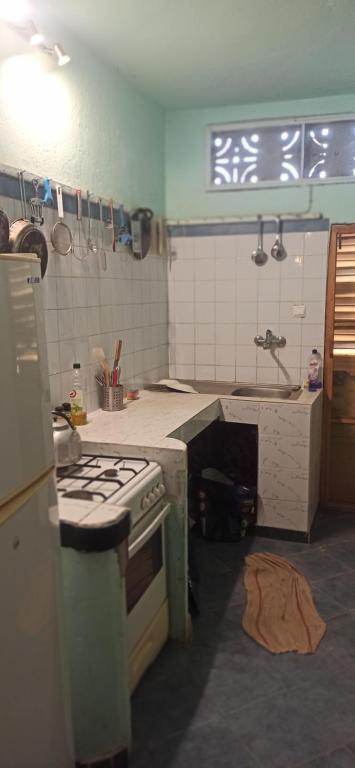 a kitchen with a stove and a sink at Chez John et Élisa in Ndangane