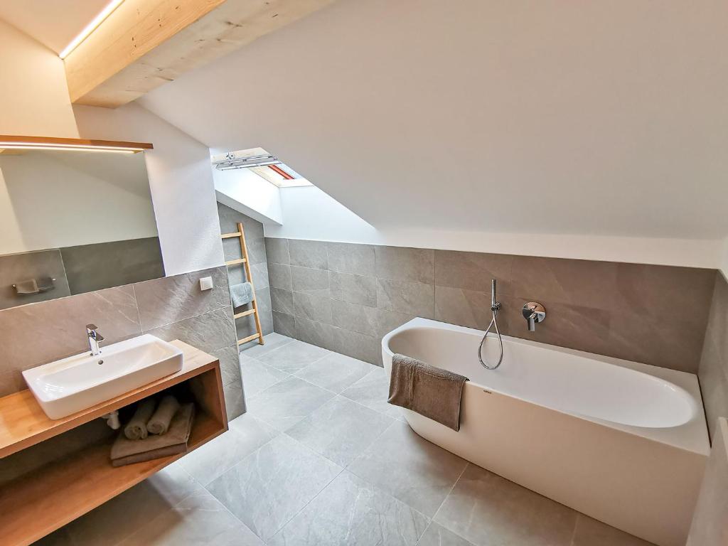 ein Badezimmer mit einer weißen Badewanne und einem Waschbecken in der Unterkunft Linderhof in Natz-Schabs