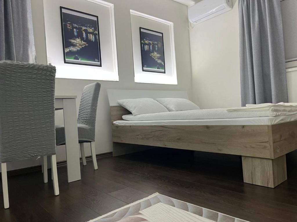 1 dormitorio con 1 cama, mesa y sillas en MSV studio apartman, en Belgrado