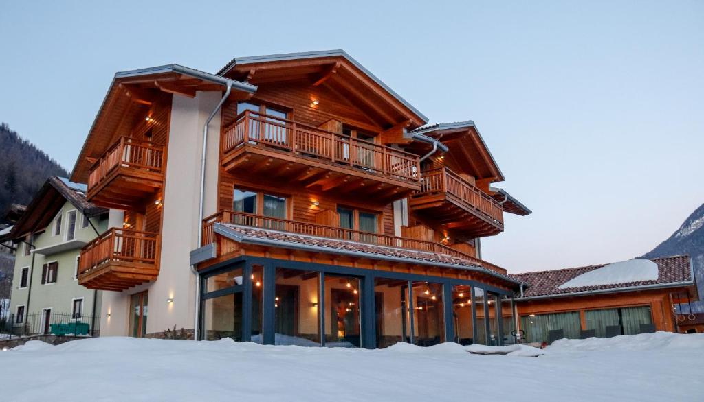 un gran edificio de madera en la nieve en Agritur Il Tempo delle Mele, en Caldes