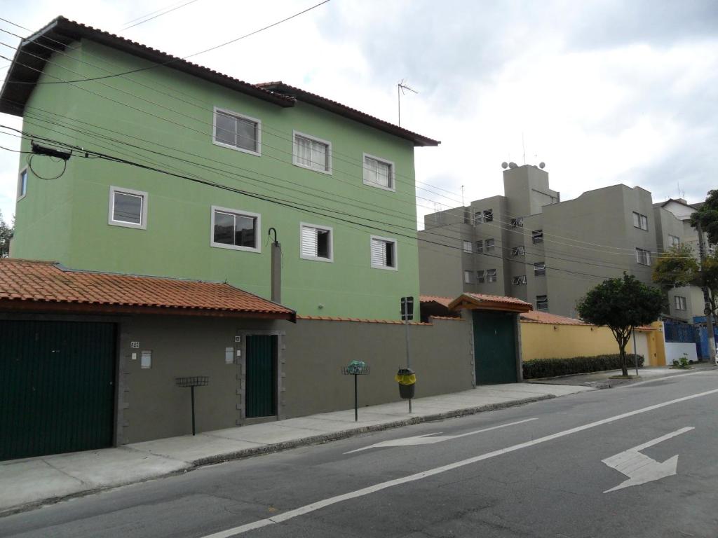 un edificio verde al lado de una calle en Hostel São José Dos Campos, en São José dos Campos