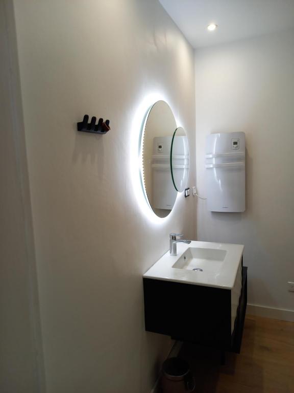 a bathroom with a sink and a mirror at Maison proche du centre ville in Pornic