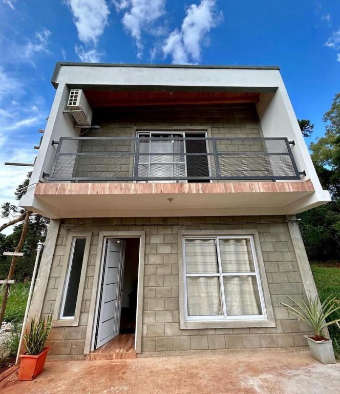 a house with a balcony on top of it at Gobernador Roca Duplex in Gobernador Roca