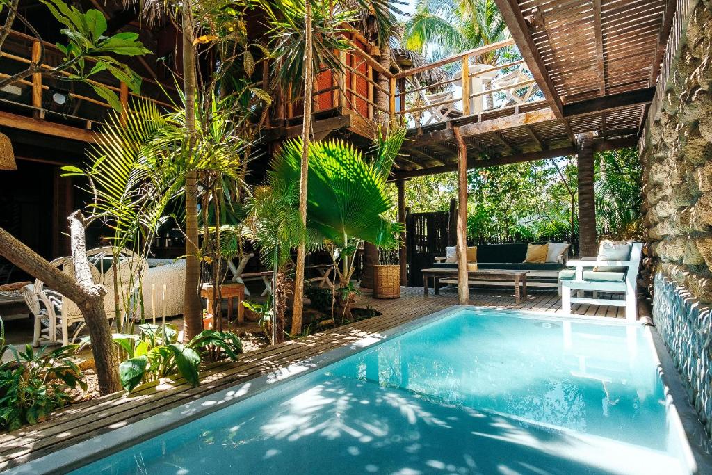 a swimming pool in a tropical house with a patio at La Maison in Máncora