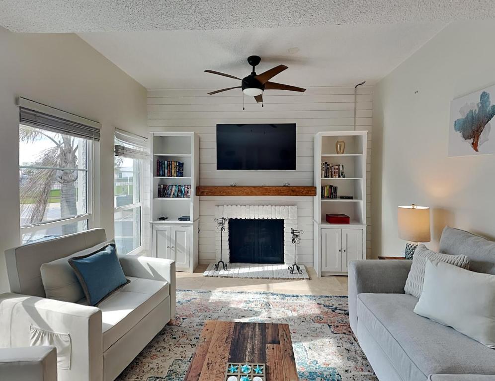 a living room with a ceiling fan and a fireplace at Madeira Beach Yacht Club 247f in St Pete Beach