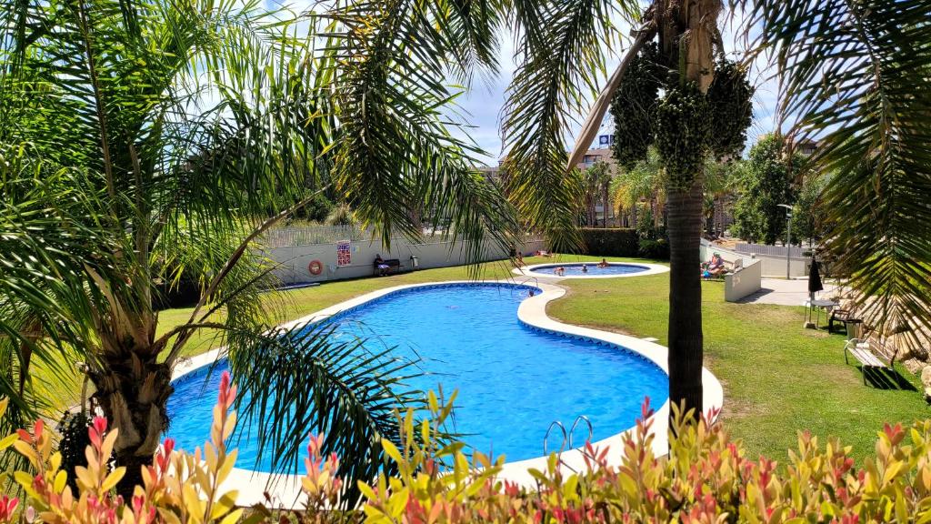 una piscina en un patio con palmeras en Entre el mar y PortAventura 2, en Salou