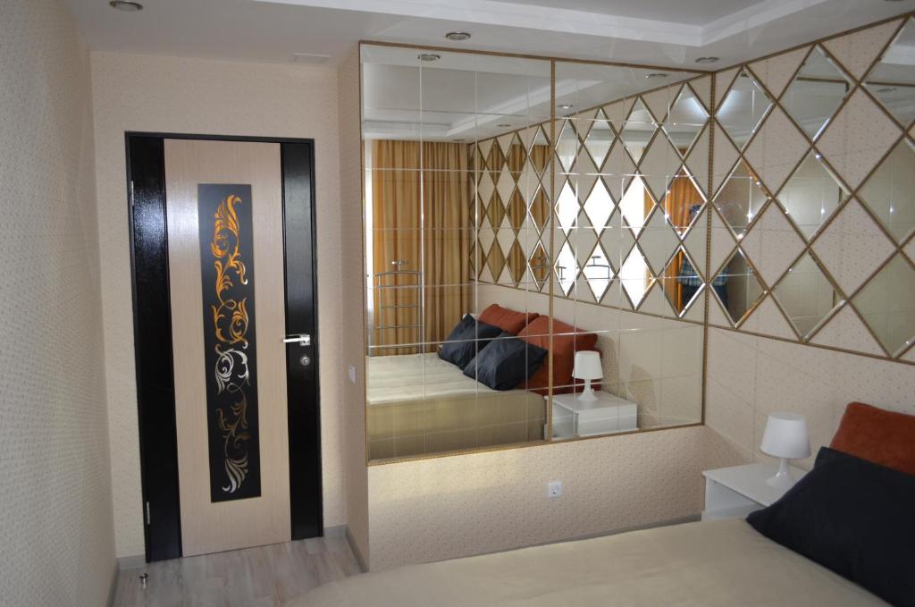 ヴォログダにあるApartment Na Lavrovaのベッド1台が備わるガラスの壁の客室です。