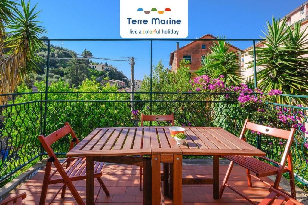 een houten tafel en stoelen op een balkon bij Nettuno, TerreMarine in Monterosso al Mare
