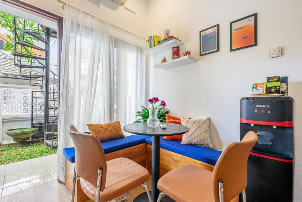 ein Raum mit einem Tisch und Stühlen und einem Fenster in der Unterkunft MONA NEST Canggu 2BR Tiny House with Rooftop and Cozy Workspace in Dalung