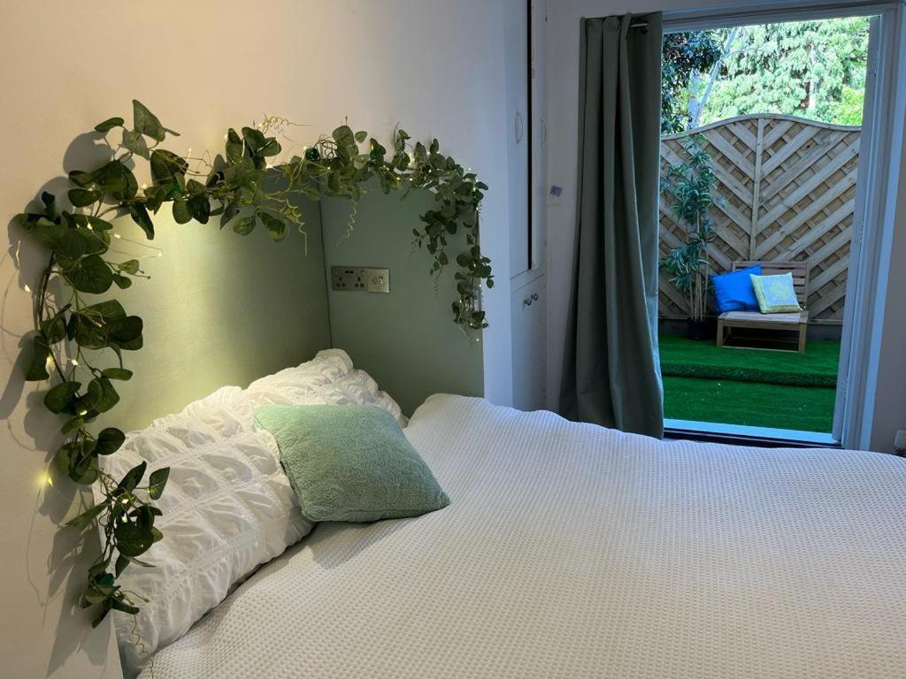a bedroom with a bed with a plant above it at Cambray Apartment in Cheltenham