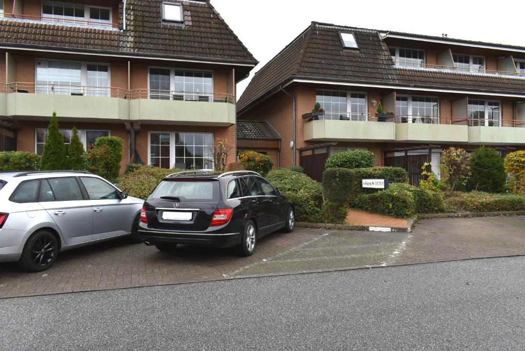 two cars parked in a parking lot in front of a building at Sonnenseite Ferienwohnung in Niendorf