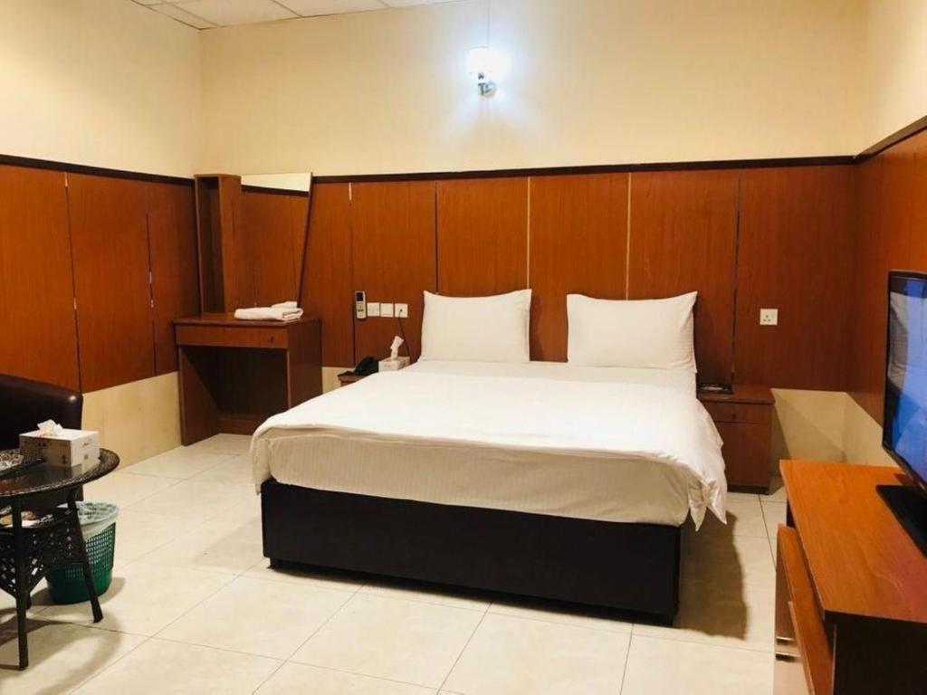 a bedroom with a large bed with wooden walls at Lulu guest house in Ras al Khaimah