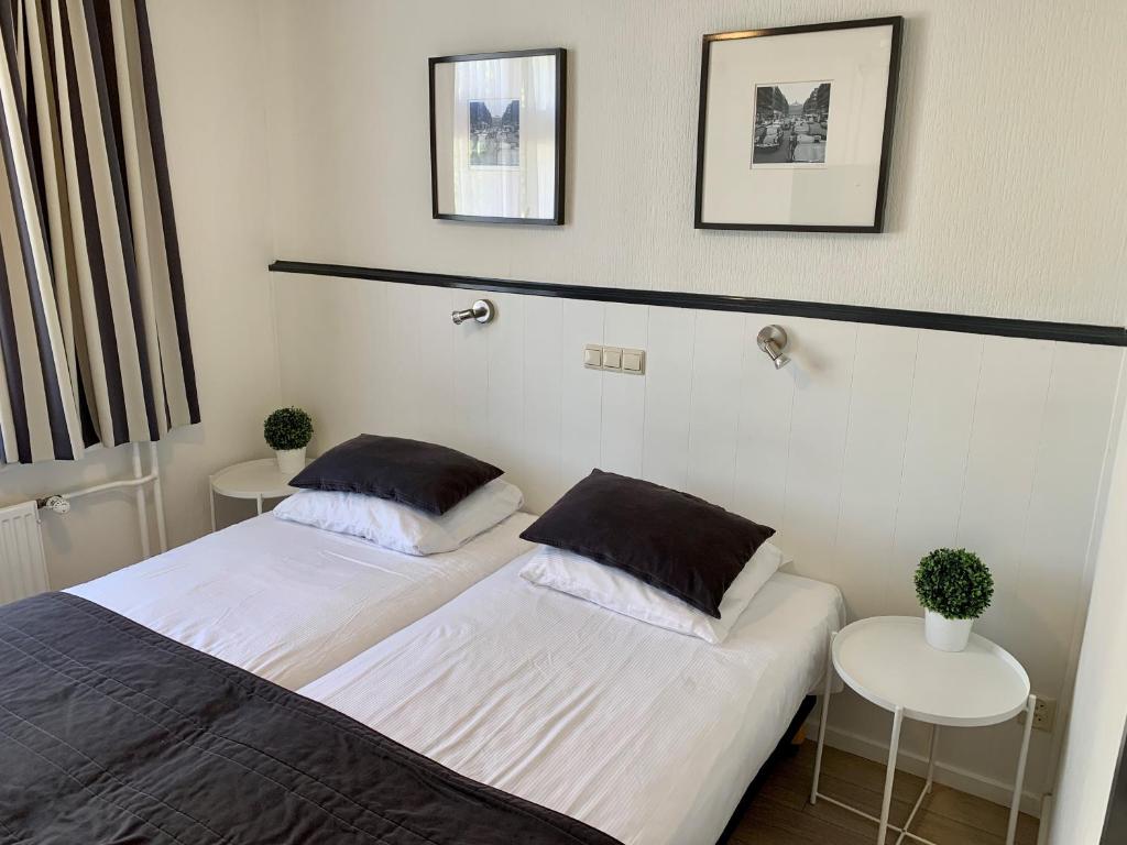 dwa łóżka w pokoju z dwoma stołami w obiekcie Hotel de la Bourse w mieście Maastricht