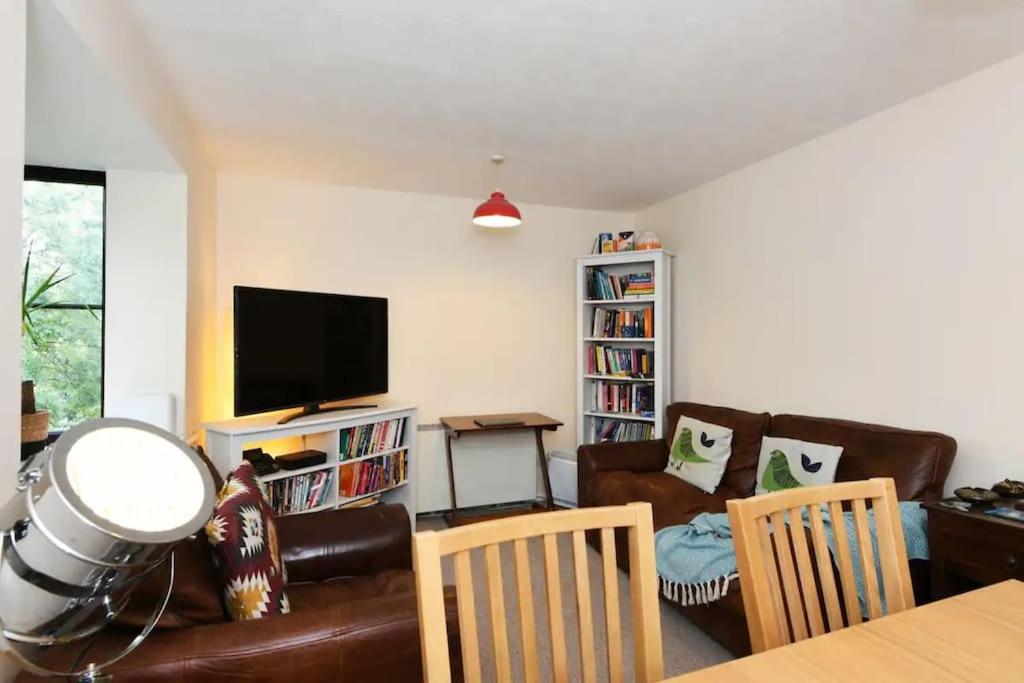 a living room with a couch and a television at Spacious Walthamstow Apartment in London