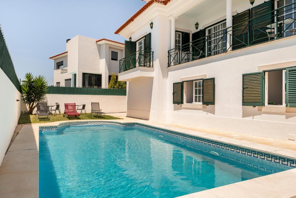 - une piscine en face d'une maison dans l'établissement Villa Privée Prestige, à Cascais