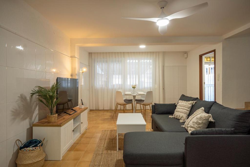 uma sala de estar com um sofá e uma televisão em Casa Calera. Con terraza y bbq em Santa Pola