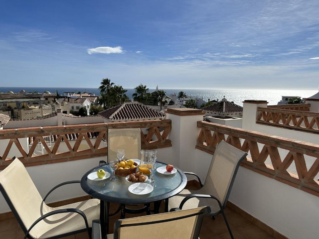 una mesa con un bol de fruta en el balcón en Nerja Paradise Rentals - Apt Chimenea C1D, en Nerja