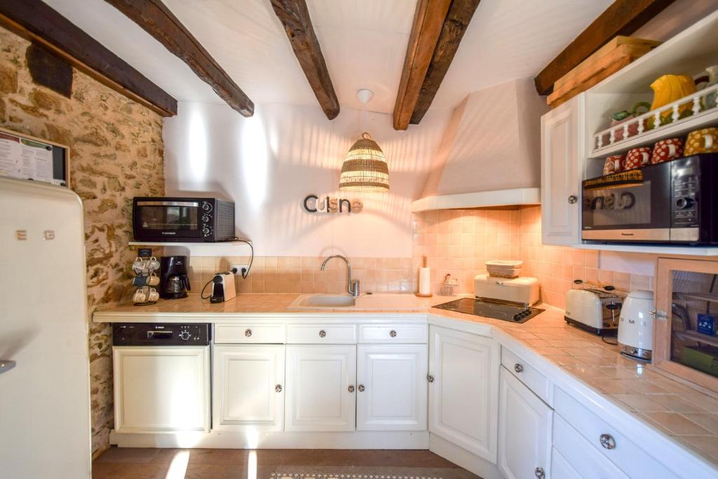 a kitchen with white cabinets and a sink at Domaine d&#39;Essendiéras in Saint-Médard-dʼExcideuil