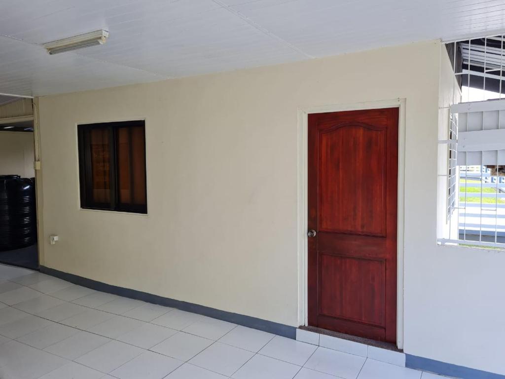 Habitación con puerta roja y pared blanca en THE NICHE STUDIO en Paramaribo