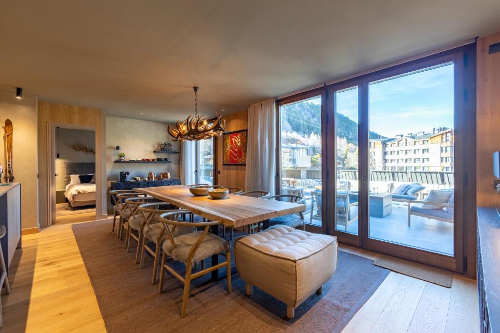 uma sala de jantar com mesa e cadeiras e uma varanda em W ISARD LODGE by Select Rentals em El Tarter