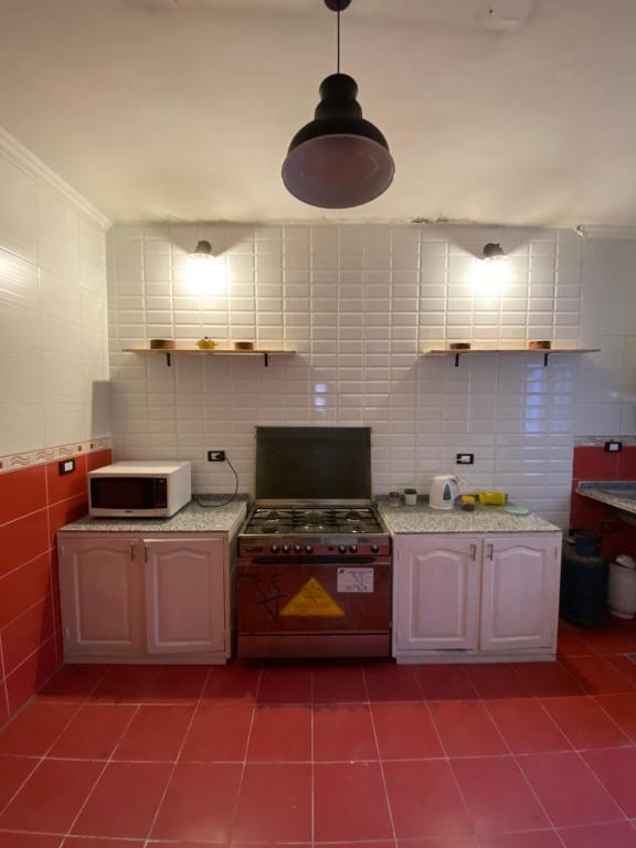 a kitchen with a stove and a microwave at luxurious apartment in Az Zaqāzīq