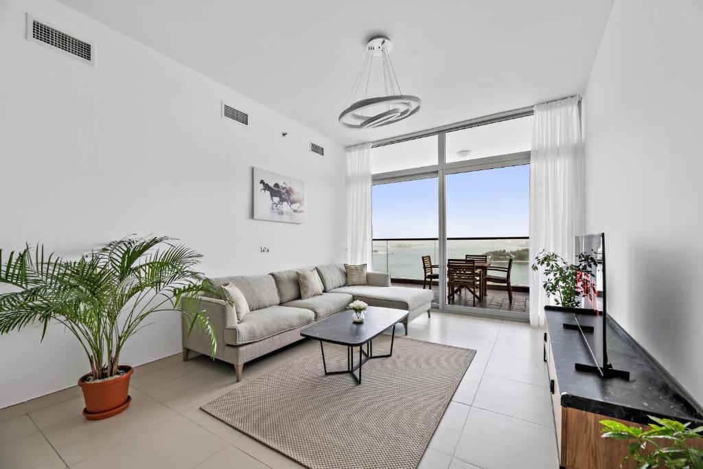 uma sala de estar com um sofá e uma mesa em VayK - Serene 1BD with Full Sea View on the Palm em Dubai