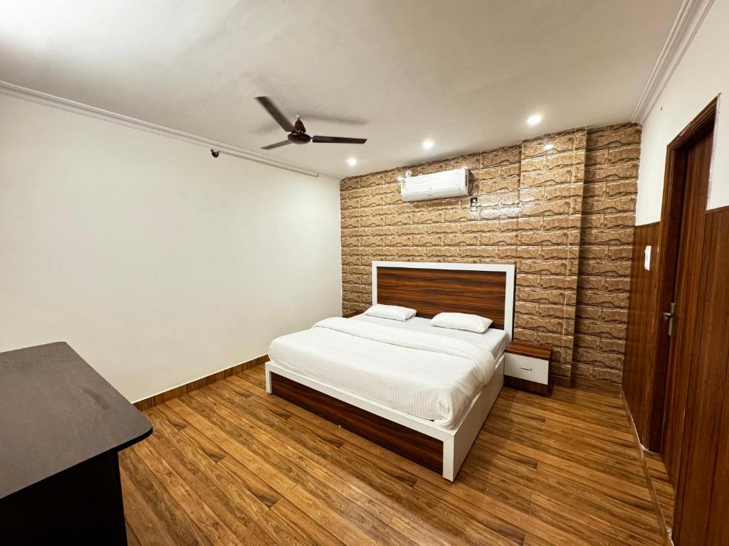 a bedroom with a bed and a brick wall at Hotel Walk Inn in Faridabad