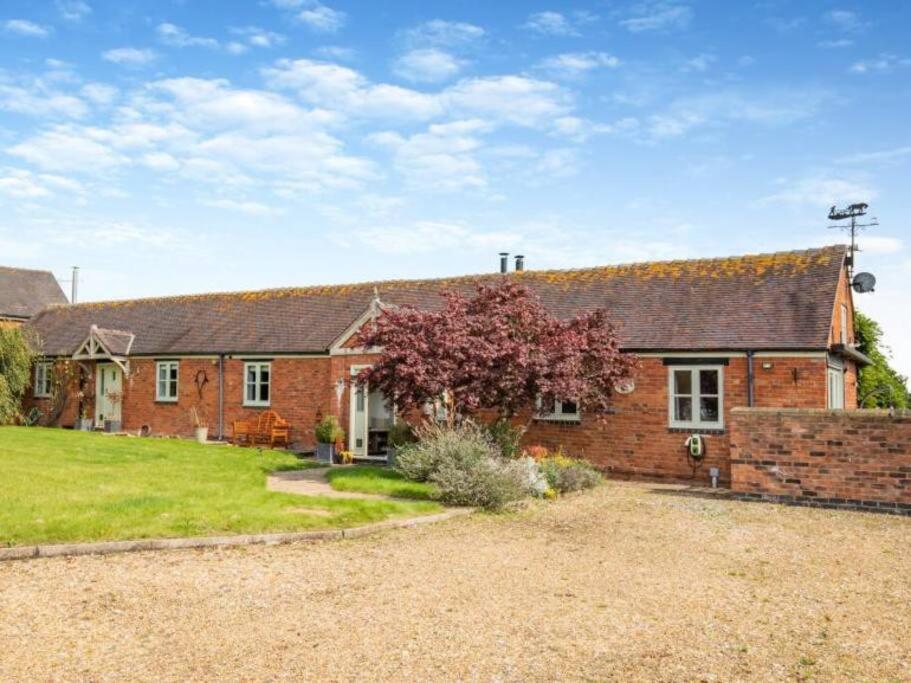 a brick house with a yard in front of it at The Stables 