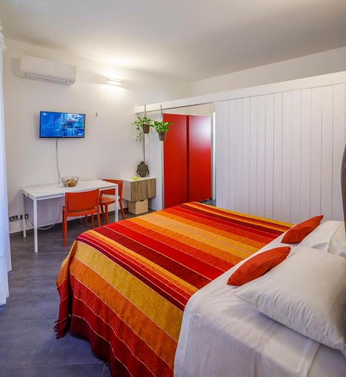 a bedroom with a bed and a desk and a table at CASA NINNI in Catania
