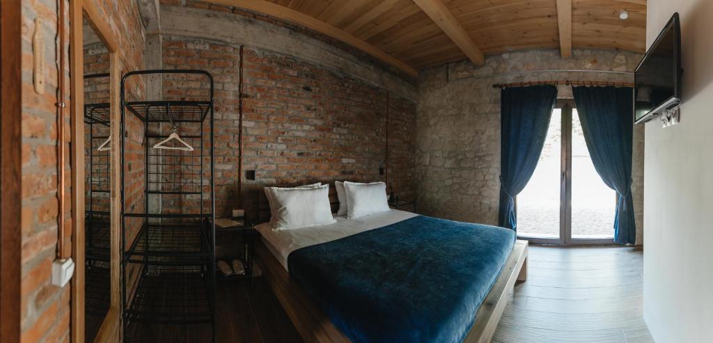 a bedroom with a bed and a brick wall at Crama Mircesti 