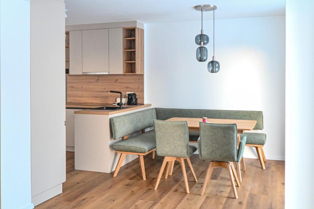 cocina y comedor con mesa y sillas en Arton Lachtal - Apartments Steiermark en Lachtal